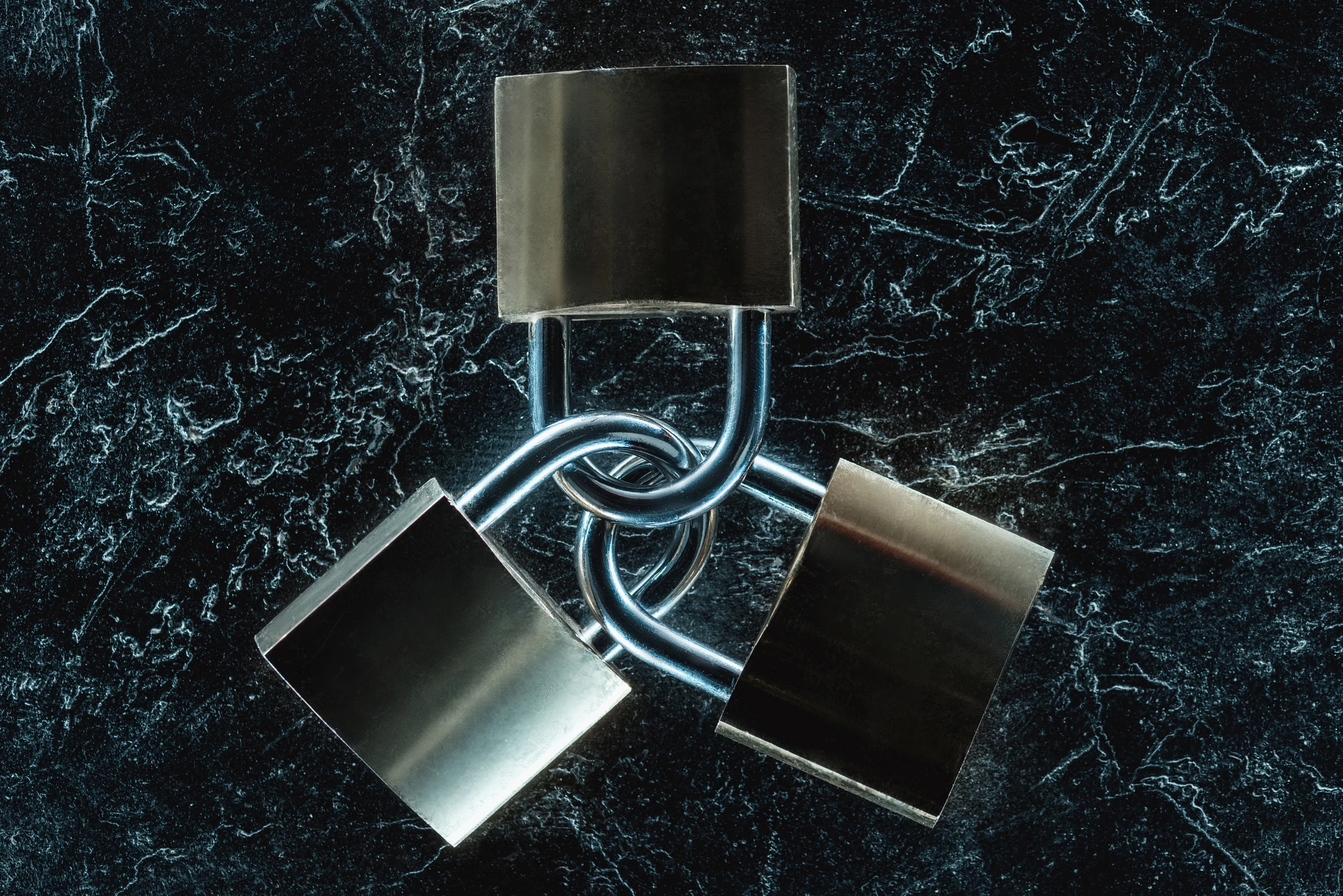 3 interlocked padlocks on dark background